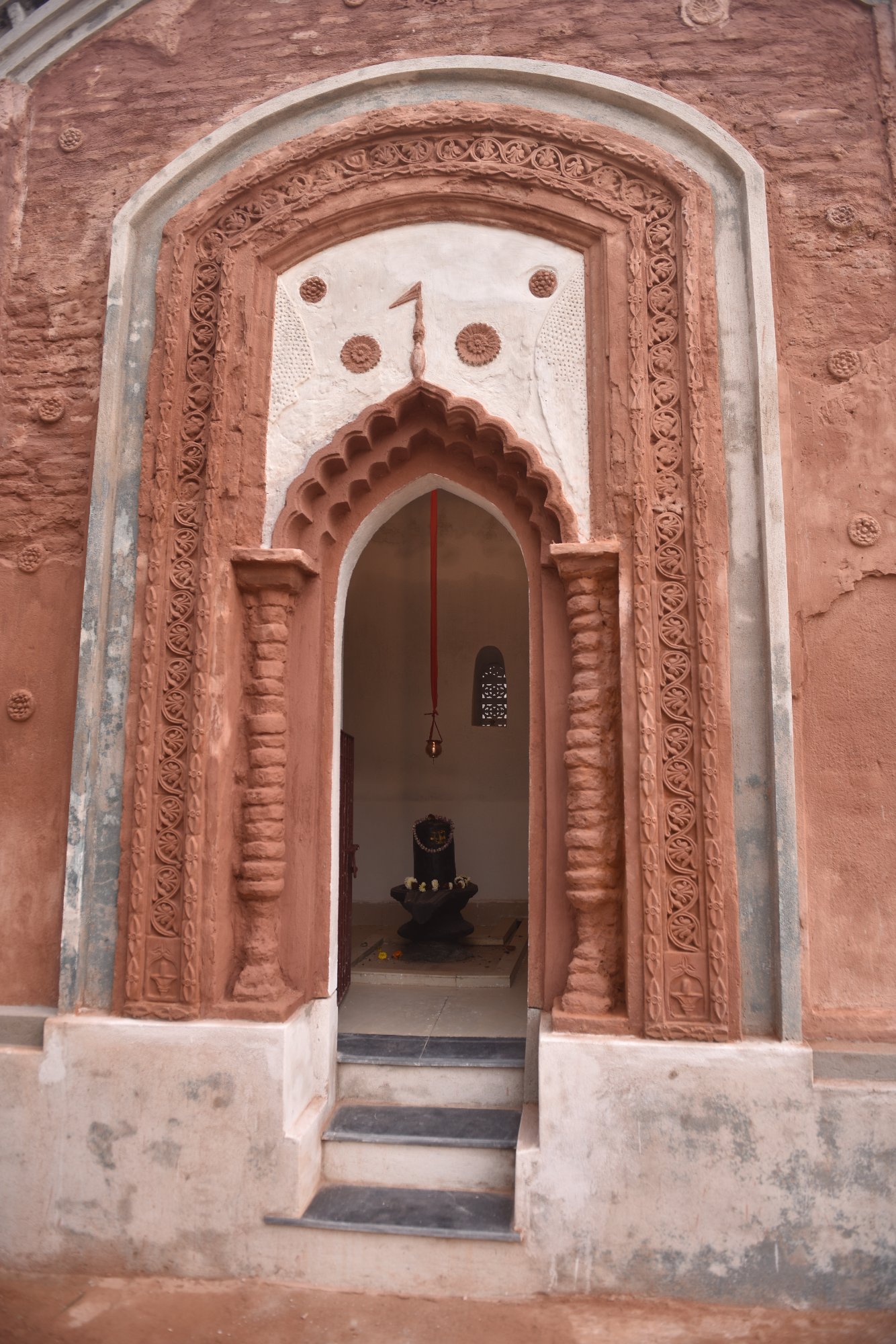 Terracotta temple arch detail — intricate carved motifs after restoration